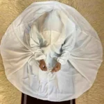 A kid wearing a plain full-length namaz chadar , showcasing its loose, flowy fit and long sleeves for complete coverage during Namaz. Clothifydotpk