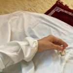 A kid wearing a plain full-length namaz chadar , showcasing its loose, flowy fit and long sleeves for complete coverage during Namaz. Clothifydotpk