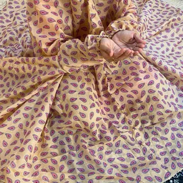 woman wearing namaz chadar with sleeves with hands raised in prayers