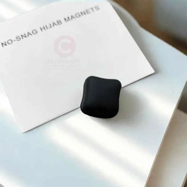 A pair of hijab magnet, demonstrating their size and use. Clothifydotpk