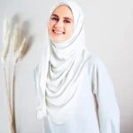 A woman wearing a white color Ready to wear double loop hijab style. By Clothifydotpk