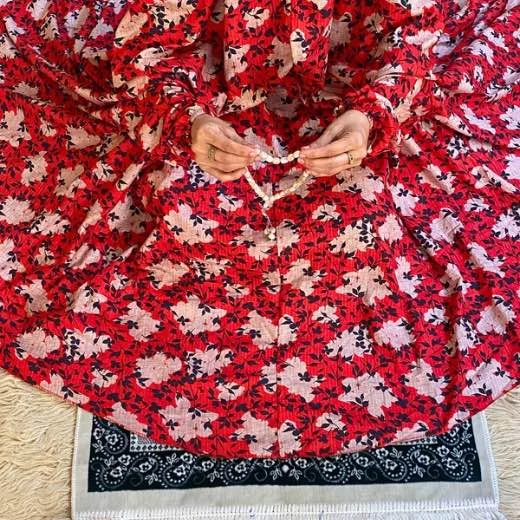 A woman using a Winter Namaz Chadar, performing namaz. Clothifydotpk