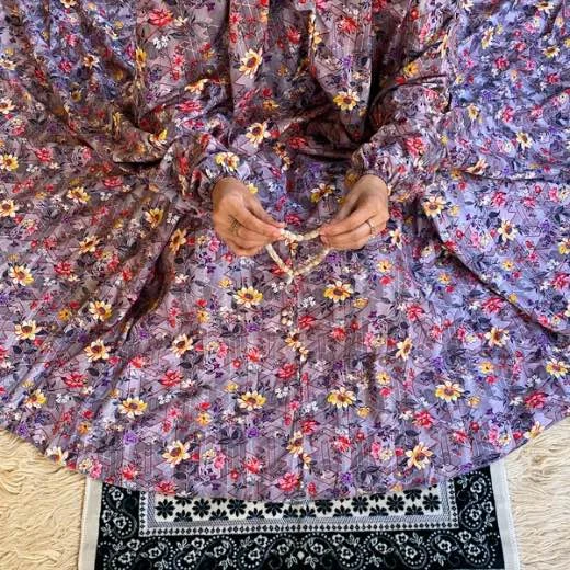 A woman using a Winter Namaz Chadar, performing namaz. Clothifydotpk