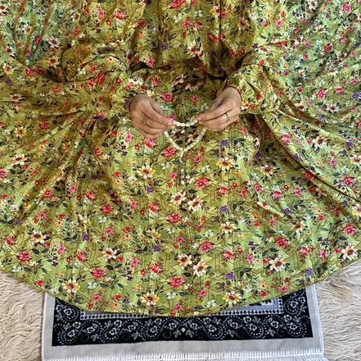 A woman using a Winter Namaz Chadar, performing namaz. Clothifydotpk