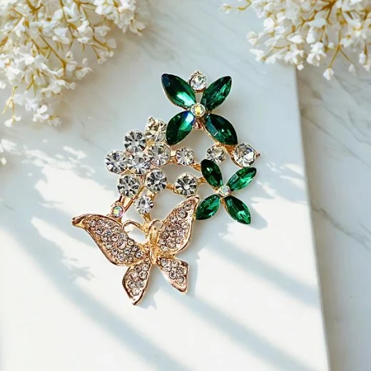 A close-up of a modern, sophisticated brooch featuring a brilliant arrangement of clear rhinestones that catch the light. By Clothifydotpk