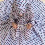 kid wearing namaz chadar with sleeves with hands raised in prayers