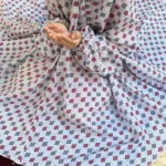 kid wearing namaz chadar with sleeves with hands raised in prayers