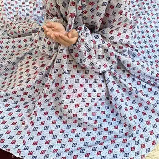 kid wearing namaz chadar with sleeves with hands raised in prayers