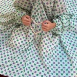 kid wearing namaz chadar with sleeves with hands raised in prayers