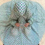 kid wearing namaz chadar with sleeves with hands raised in prayers