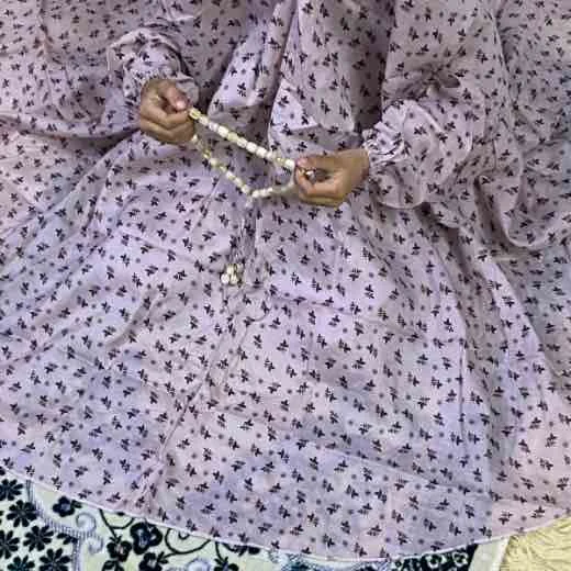 A young kid wearing a Namaz Chadar, made from breathable fabric. By Clothifydotpk