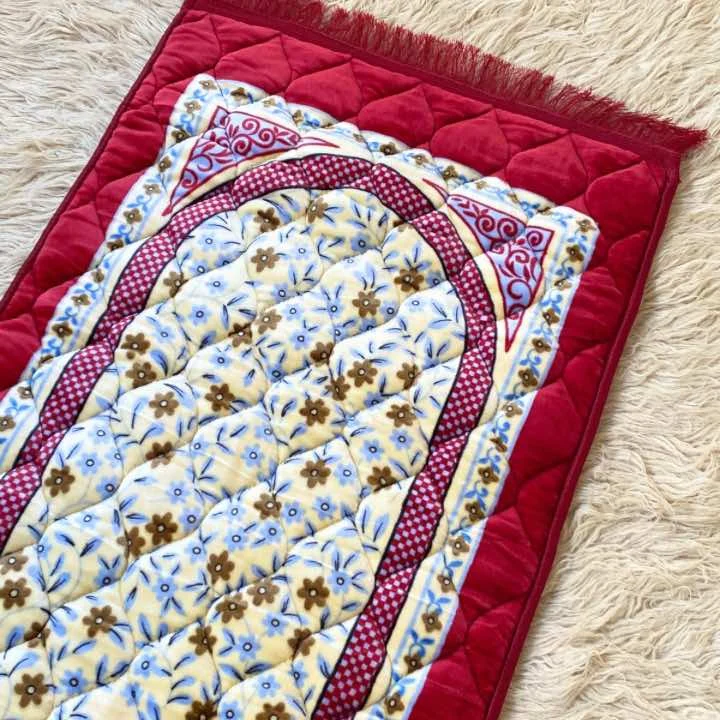 A beautifully patterned quilted prayer mat laid out flat By Clothifydotpk