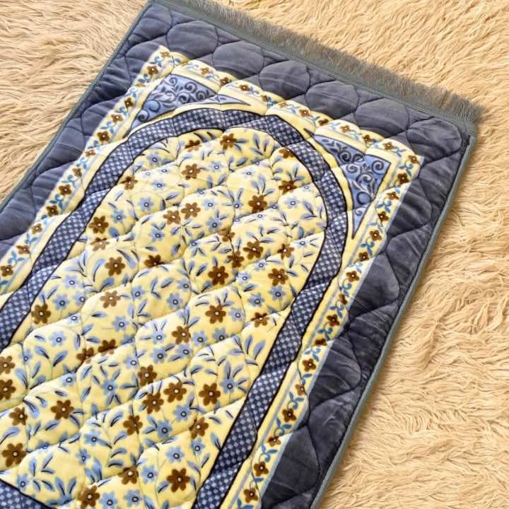A beautifully patterned quilted prayer mat laid out flat By Clothifydotpk