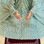 A women peacefully performing salah wearing printed namaz chadar.
