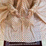A women peacefully performing salah wearing printed namaz chadar.