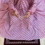 A women peacefully performing salah wearing printed namaz chadar.