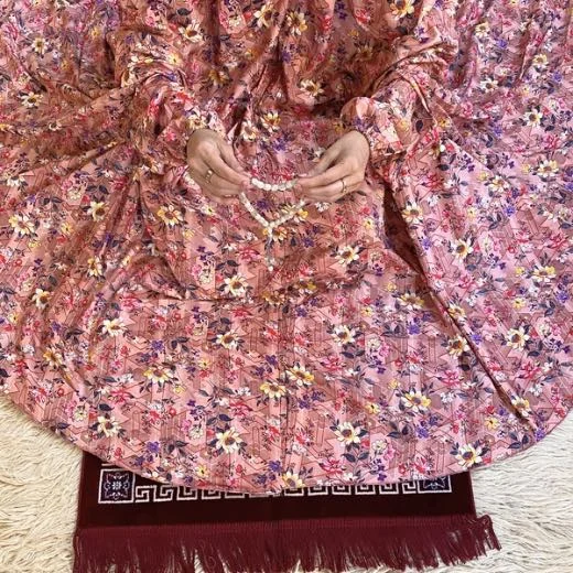 A woman using a Winter Namaz Chadar, performing namaz By Clothifydotpk