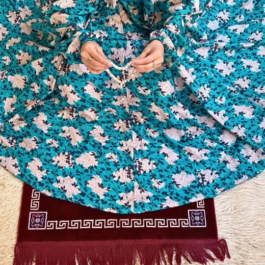 A woman using a Winter Namaz Chadar, performing namaz By Clothifydotpk