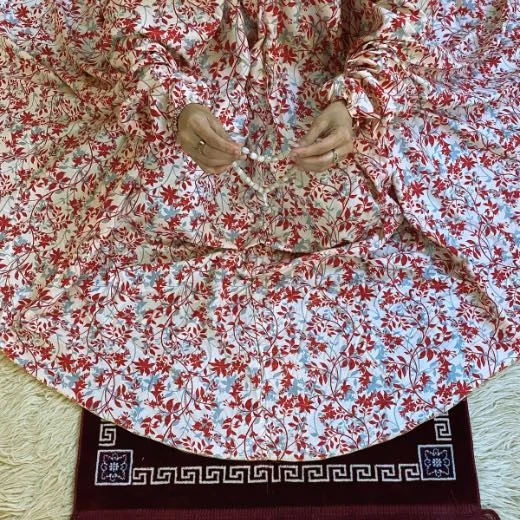 A woman using a Winter Namaz Chadar, performing namaz By Clothifydotpk