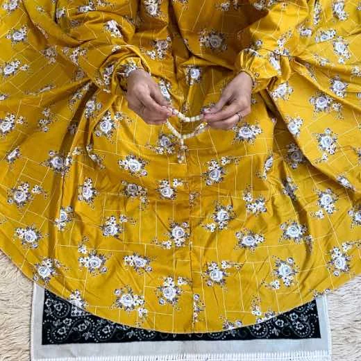 A woman using a Winter Namaz Chadar, performing namaz By Clothifydotpk