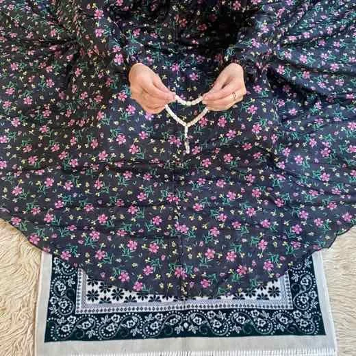 A woman using a breathable soft swiss lawn Namaz Chadar with Sleeves, performing salah By Clothifydotpk