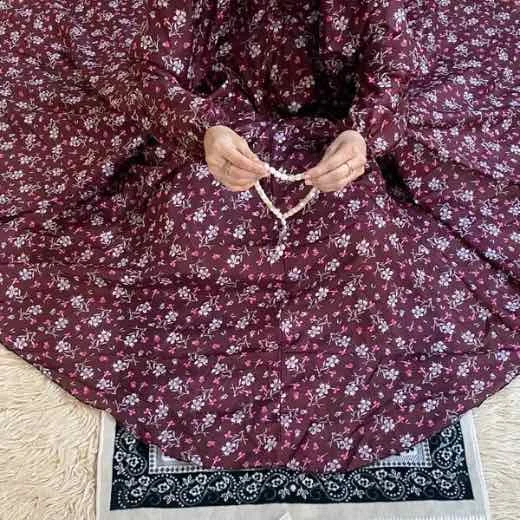 A woman using a breathable soft swiss lawn Namaz Chadar with Sleeves, performing salah By Clothifydotpk