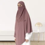 A woman wearing a long, single layer khimar that drapes over the head, and shoulders, falling to about waist length.