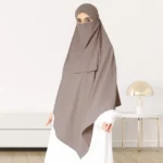 A woman wearing a long, single layer khimar that drapes over the head, and shoulders, falling to about waist length.