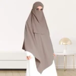 A woman wearing a long, single layer khimar that drapes over the head, and shoulders, falling to about waist length.