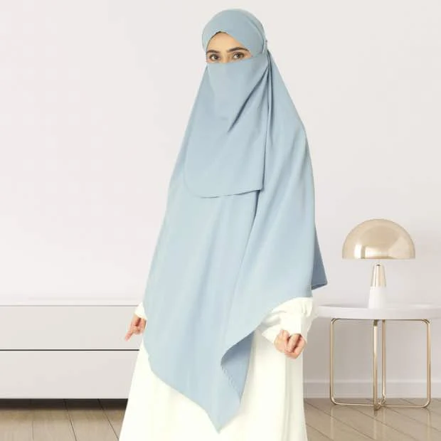 A woman wearing a long, single layer khimar that drapes over the head, and shoulders, falling to about waist length.
