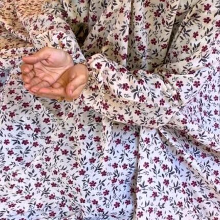 A woman using a breathable soft swiss lawn Namaz Chadar with Sleeves, performing salah By Clothifydotpk