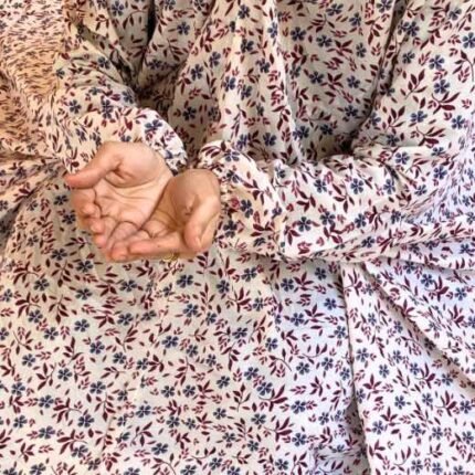 A woman using a breathable soft swiss lawn Namaz Chadar with Sleeves, performing salah By Clothifydotpk
