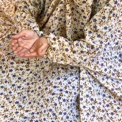 A woman using a breathable soft swiss lawn Namaz Chadar with Sleeves, performing salah By Clothifydotpk