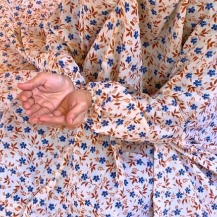 A woman using a breathable soft swiss lawn Namaz Chadar with Sleeves, performing salah By Clothifydotpk