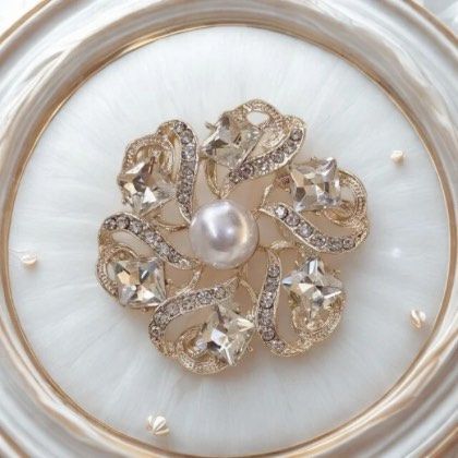 A close-up of a pearl brooch.