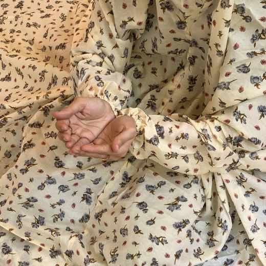 A woman using a breathable soft swiss lawn Namaz Chadar with Sleeves and pocket, performing salah By Clothifydotpk