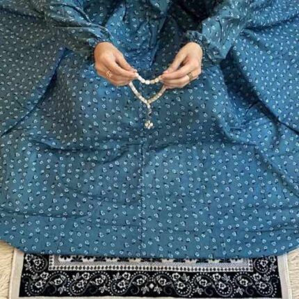 A woman using a breathable soft swiss lawn Namaz Chadar with pocket, performing salah By Clothifydotpk