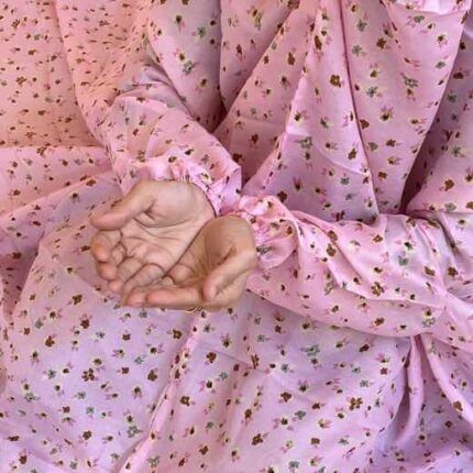 A woman using a breathable soft swiss lawn Namaz Chadar with sleeves, performing salah By Clothifydotpk