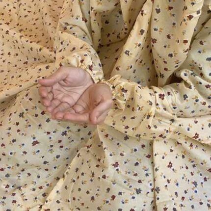 A woman using a breathable soft swiss lawn Namaz Chadar with sleeves, performing salah By Clothifydotpk