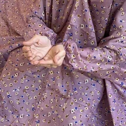 A woman using a breathable soft swiss lawn Namaz Chadar with sleeves, performing salah By Clothifydotpk