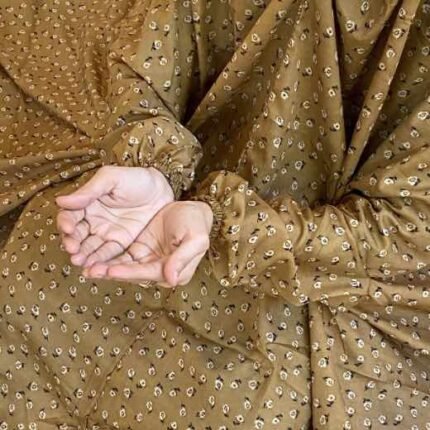 A woman using a breathable soft swiss lawn Namaz Chadar with sleeves, performing salah By Clothifydotpk
