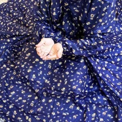 A woman using a breathable soft swiss lawn Namaz Chaddar with Sleeves, performing salah By Clothifydotpk