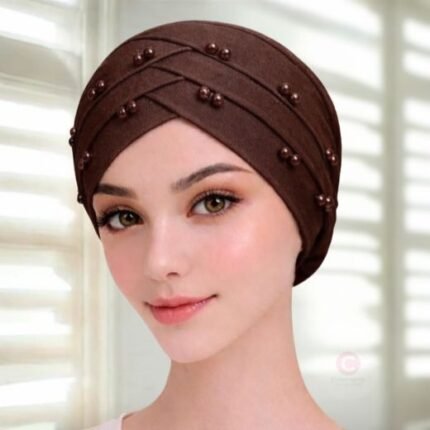 A woman wearing a tie-back fancy 3 layer pearl hijab cap with delicate pearls, visible under a sheer or light hijab.