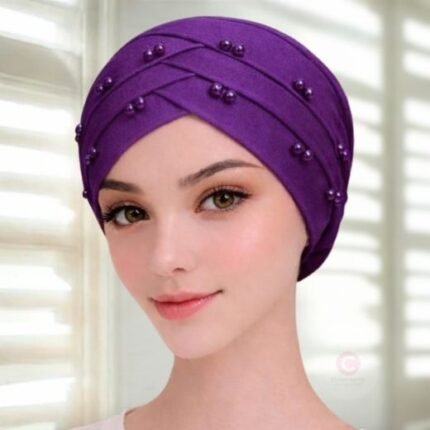 A woman wearing a tie-back fancy 3 layer pearl hijab cap with delicate pearls, visible under a sheer or light hijab.