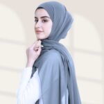 A woman wearing a ready-to-wear instant chiffon hijab, featuring a soft, flowy drape and pre-stitched design for easy wear with inner under cap. By Clothifydotpk