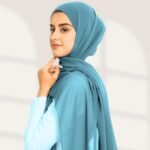 A woman wearing a ready-to-wear instant chiffon hijab, featuring a soft, flowy drape and pre-stitched design for easy wear with inner under cap. By Clothifydotpk