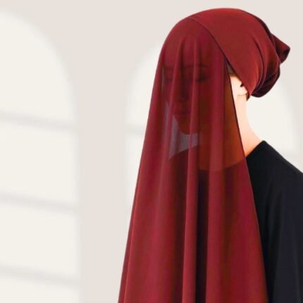 A woman wearing a maroon color ready-to-wear instant chiffon hijab, featuring a soft, flowy drape and pre-stitched design for easy wear with inner under cap. By Clothifydotpk