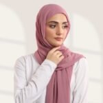 A woman wearing a tea pink color ready-to-wear instant chiffon hijab, featuring a soft, flowy drape and pre-stitched design for easy wear with inner under cap. By Clothifydotpk