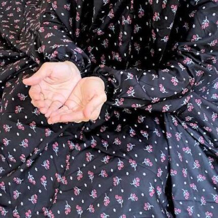 A woman using a breathable soft swiss lawn Namaz Chadar with Sleeves, performing salah By Clothifydotpk