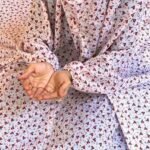 A woman using a breathable soft swiss lawn Namaz Chadar with Sleeves, performing salah By Clothifydotpk